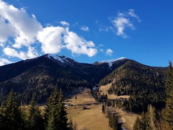 Scenic view of landscape and mountains against blue sky