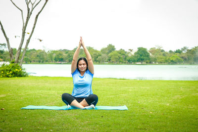 Full length of woman sitting on grass