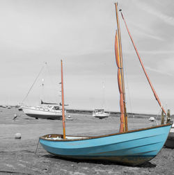 Sailboats moored on sea against sky