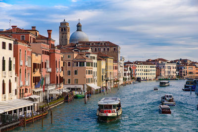 Boats in canal amidst buildings in city