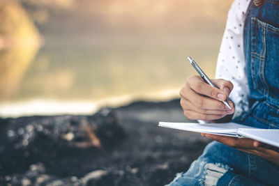 Midsection of woman reading book