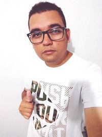 Portrait of young man standing against white background