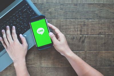 Midsection of woman using mobile phone on table