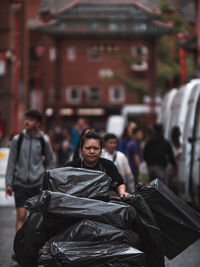 People sitting on street against buildings in city