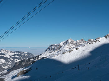 Scenic view of snowcapped mountains against clear blue sky