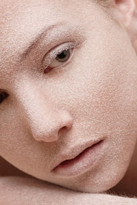 Close-up portrait of young woman with powder on face