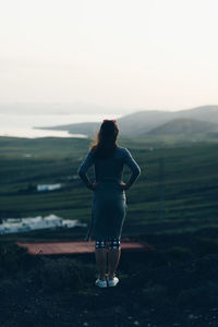 Rear view of woman standing on landscape