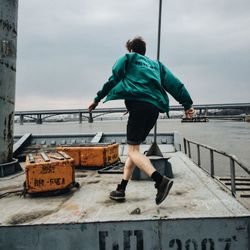 Rear view full length of man walking on boat at river