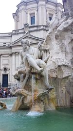 Statue of fountain in front of historical building