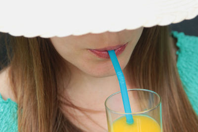 Close-up portrait of a young woman drinking glass