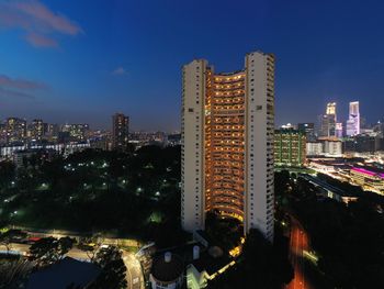 Illuminated buildings in city against sky at night