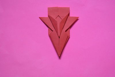 High angle view of paper with pink pencils against colored background