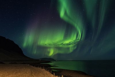 Scenic view of landscape against sky at night