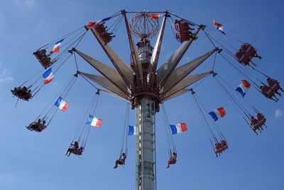 Low angle view of chain swing ride against sky