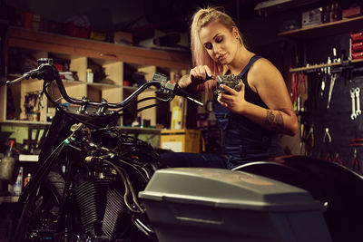 Mechanic repairing motorcycle in workshop