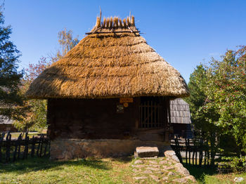 View of cottage in village against clear sky
