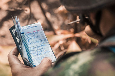 Midsection of man holding paper with text