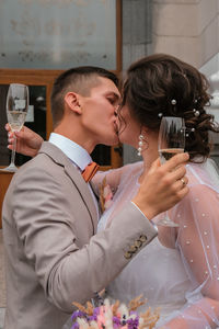 Groom hug and kiss bride in palm grove. wedding day for two. lovely weeding couple. young lovers. 