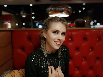 Portrait of smiling young woman sitting at restaurant