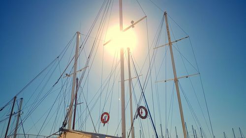 Low angle view of boats against clear blue sky