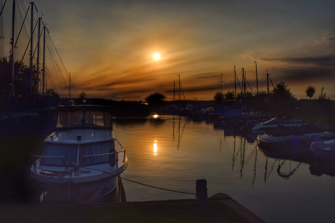 sunset, nautical vessel, transportation, moored, water, mode of transport, boat, sky, sun, reflection, cloud, cloud - sky, scenics, tranquility, tranquil scene, harbor, calm, beauty in nature, nature, sea, dramatic sky, sunbeam, no people, waterfront, marina, cloudy, non-urban scene, atmosphere