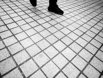 Low section of man standing on tiled floor