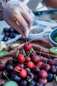 Cropped hand of woman holding cherry 