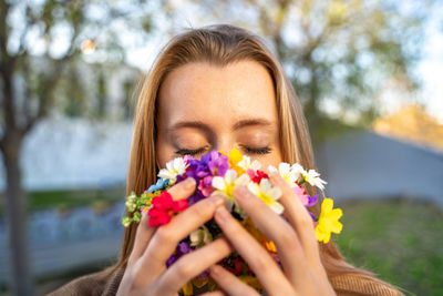 Close-up of woman holding pink flower