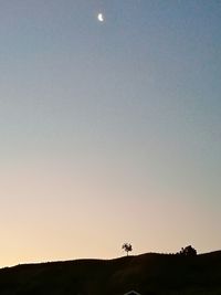 Scenic view of silhouette field against clear sky during sunset