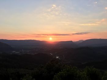 Scenic view of silhouette mountains against sky at sunset