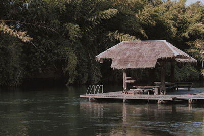 Built structure by lake against trees