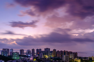 Modern buildings against sky during sunset