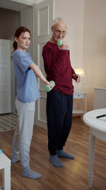 Full length of mother and daughter standing in bathroom