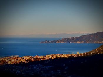 City by sea against sky during sunset