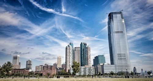 Low angle view of modern buildings against cloudy sky