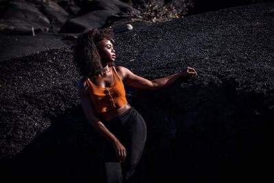 High angle view of young woman standing against black background