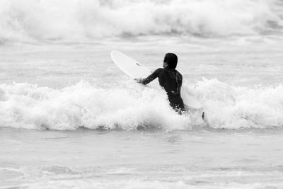 Man surfing on sea against sky