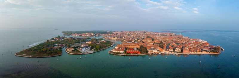 High angle view of townscape by sea against sky