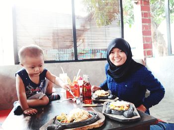 Portrait of happy woman sitting with food