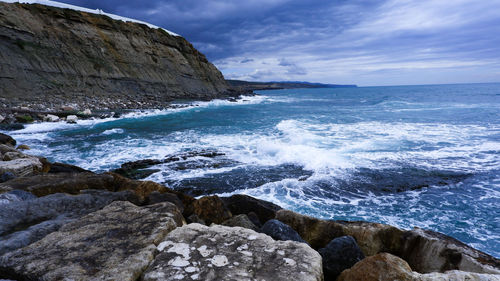 Scenic view of rocks in sea against sky