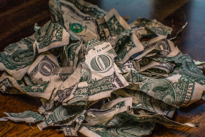 Close-up crumpled and torn us paper currency on table