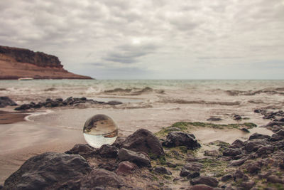 Scenic view of rocks on beach against sky