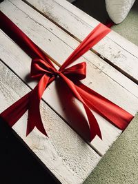Close-up of ribbon tied wooden gift container on carpet