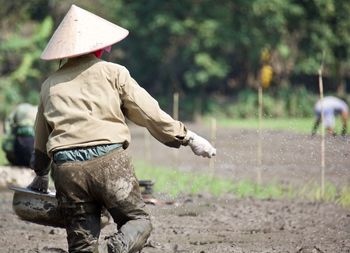 Rear view of farmer working on field