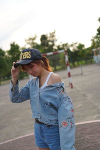 Portrait of a smiling young woman standing on road