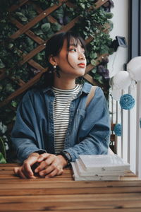 Girl looking away while sitting on table