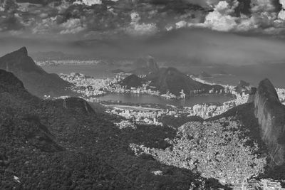 Aerial view of city by mountains against sky