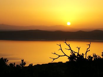 Scenic view of lake against orange sky