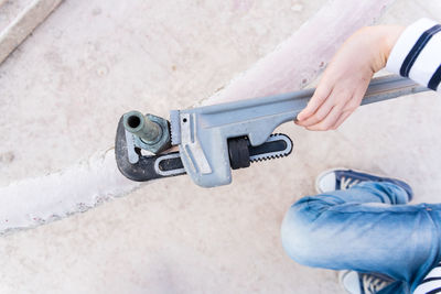 Low section of man using large wrench