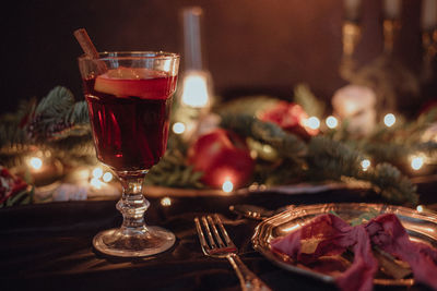 Christmas academia vintage romantic table with fir, candles, mulled wine, red decorations